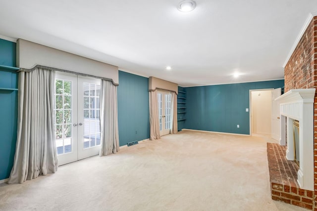 living room with a brick fireplace, carpet floors, and french doors