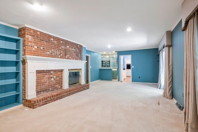 unfurnished living room featuring crown molding, light colored carpet, and a fireplace