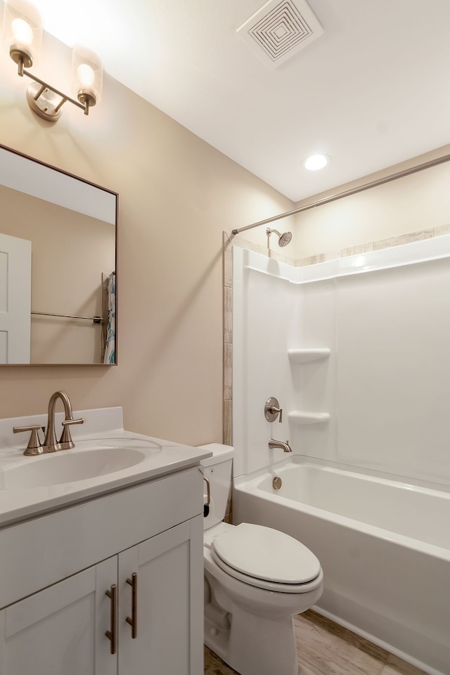 full bathroom featuring hardwood / wood-style flooring, bathtub / shower combination, vanity, and toilet