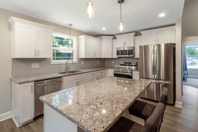 kitchen featuring appliances with stainless steel finishes, sink, tasteful backsplash, and a kitchen island