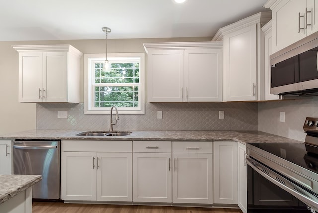 kitchen with white cabinets, stainless steel appliances, backsplash, hardwood / wood-style floors, and sink