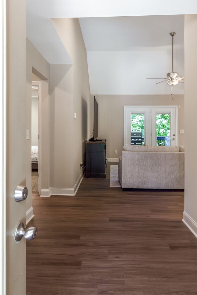 unfurnished living room featuring vaulted ceiling, dark hardwood / wood-style flooring, and ceiling fan