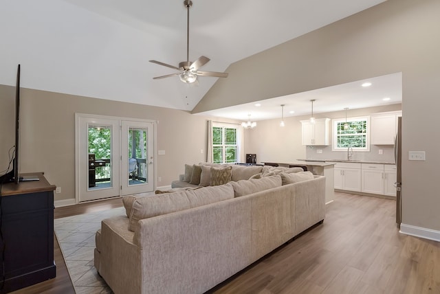 living room featuring plenty of natural light, ceiling fan, and light hardwood / wood-style flooring