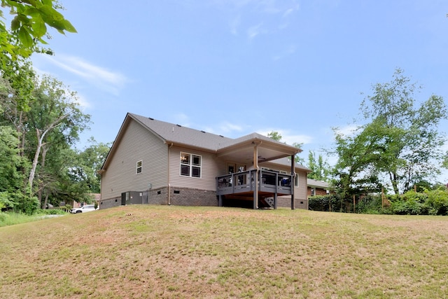 rear view of property featuring a lawn and a wooden deck