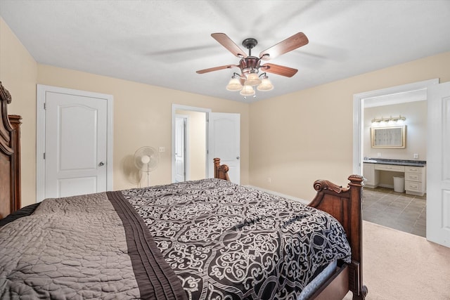 bedroom with ensuite bathroom, ceiling fan, and light carpet