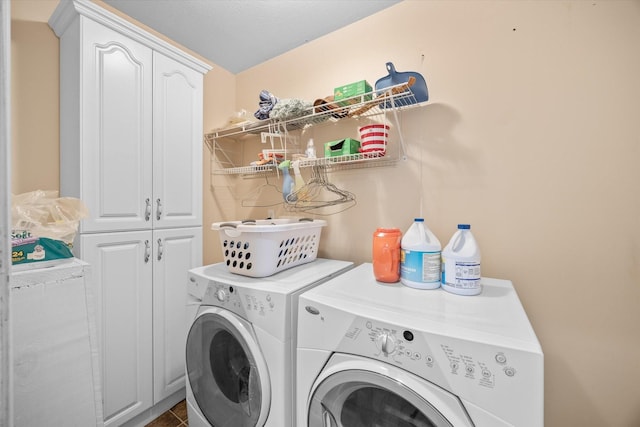 clothes washing area featuring cabinets, a textured ceiling, and separate washer and dryer