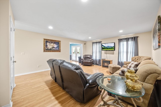 living room featuring light hardwood / wood-style floors, a wealth of natural light, and french doors