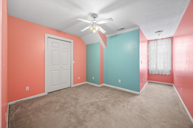 unfurnished bedroom featuring a closet, light colored carpet, and ceiling fan