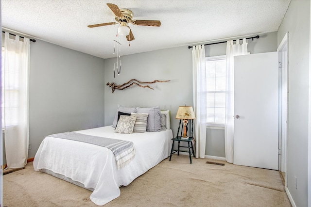 bedroom with light carpet, multiple windows, and ceiling fan