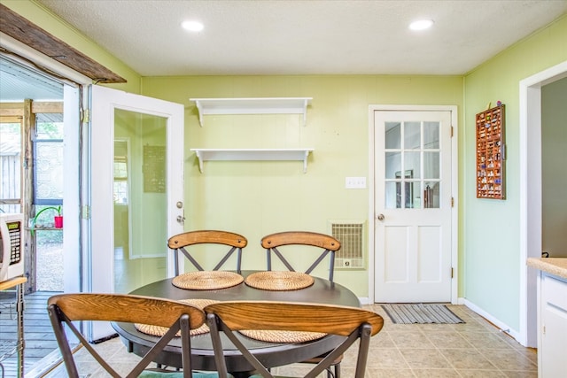 tiled dining area featuring a textured ceiling