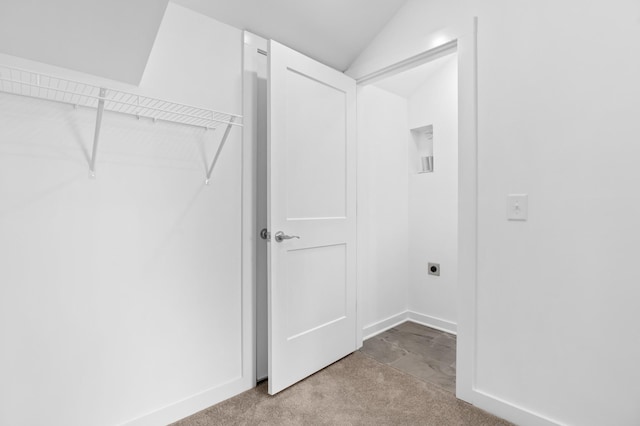 interior space featuring hookup for an electric dryer and light carpet