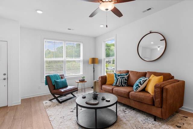 living room with ceiling fan, plenty of natural light, and light wood-type flooring