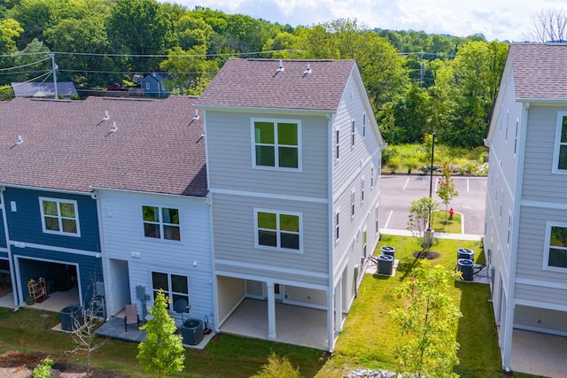 back of property featuring cooling unit, a yard, and a patio