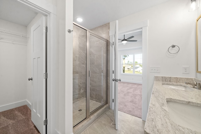 bathroom with a shower with door, vanity, and ceiling fan