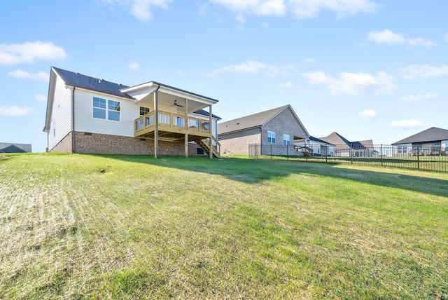 back of house featuring a wooden deck, a yard, and ceiling fan