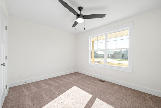 unfurnished room with ceiling fan and carpet