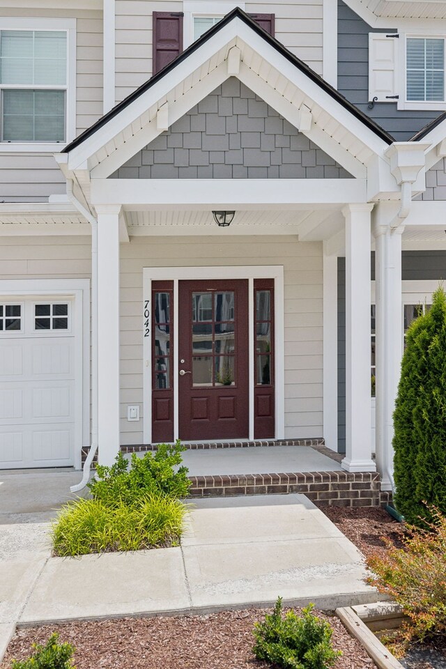 doorway to property featuring a garage and covered porch