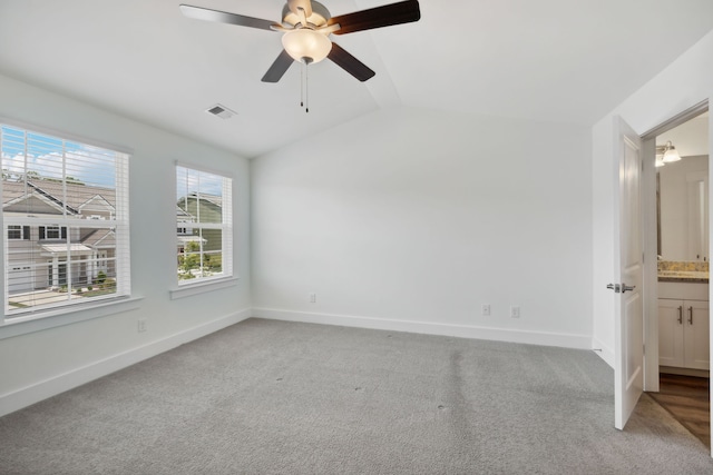 carpeted spare room featuring ceiling fan and lofted ceiling