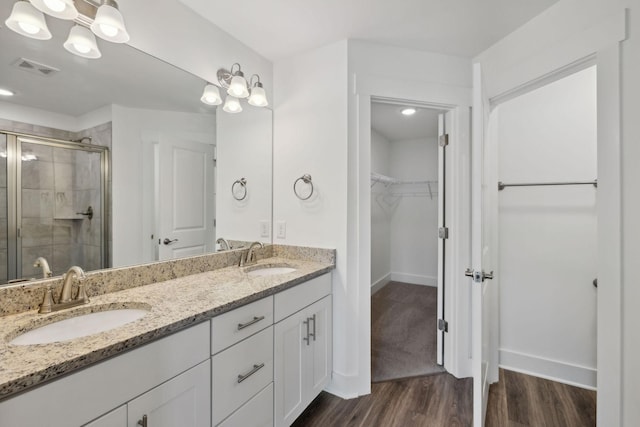 bathroom featuring hardwood / wood-style flooring, vanity, and walk in shower