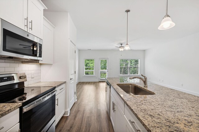 kitchen featuring ceiling fan, decorative backsplash, appliances with stainless steel finishes, and hardwood / wood-style floors