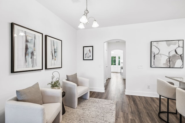 living area with dark wood-type flooring and a chandelier