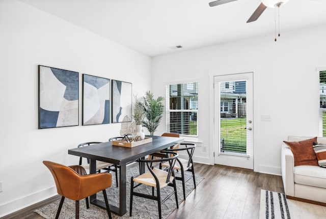 dining space with ceiling fan and dark hardwood / wood-style floors