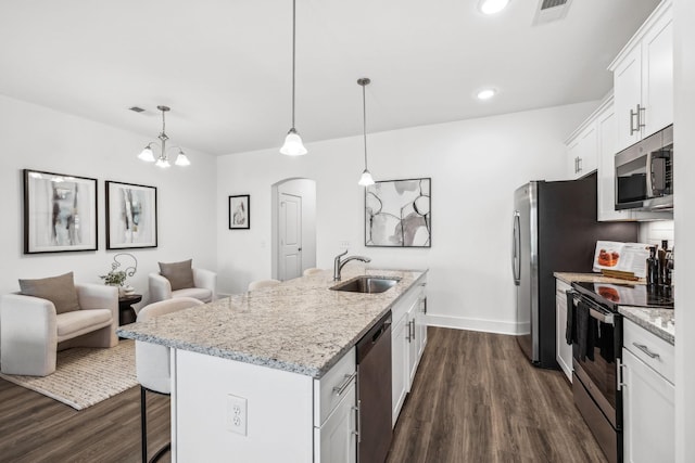 kitchen with white cabinetry, an island with sink, decorative light fixtures, sink, and appliances with stainless steel finishes