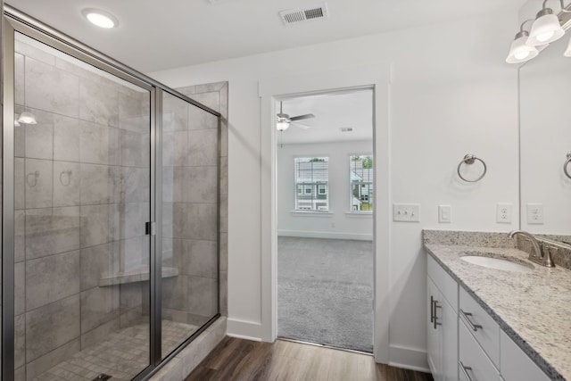 bathroom featuring hardwood / wood-style flooring, vanity, walk in shower, and ceiling fan