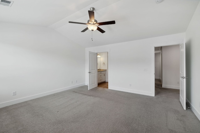 unfurnished bedroom featuring ceiling fan, carpet flooring, vaulted ceiling, and connected bathroom