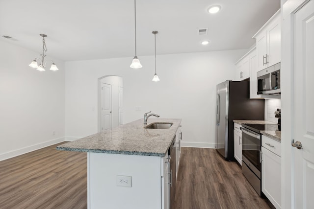 kitchen featuring pendant lighting, dark hardwood / wood-style flooring, a kitchen island with sink, appliances with stainless steel finishes, and sink