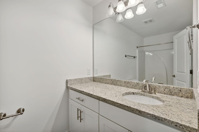 bathroom featuring a shower and vanity