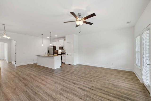 unfurnished living room with light hardwood / wood-style floors, sink, and ceiling fan