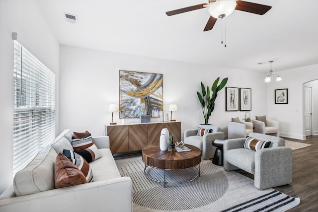 living room featuring ceiling fan with notable chandelier and hardwood / wood-style floors