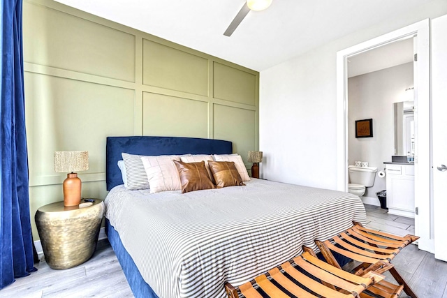 bedroom featuring ceiling fan, connected bathroom, and light hardwood / wood-style flooring