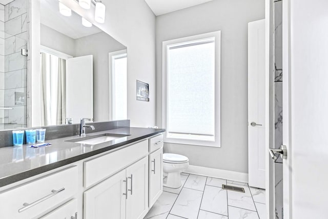 bathroom featuring vanity, toilet, and a shower with shower door