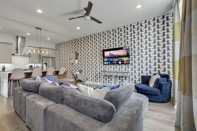 living room featuring light hardwood / wood-style flooring and ceiling fan