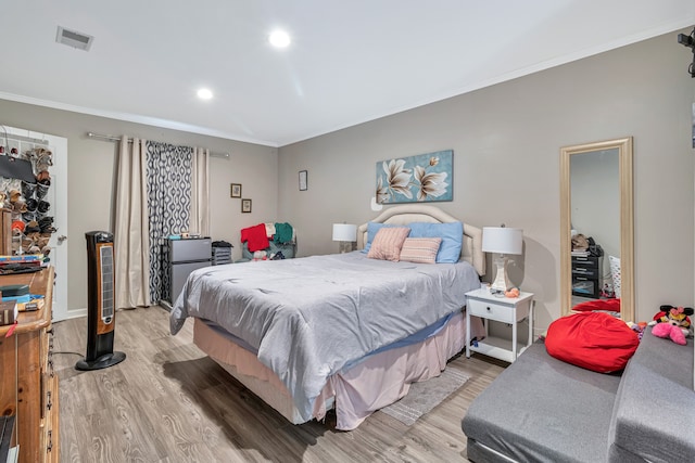 bedroom with crown molding and wood-type flooring