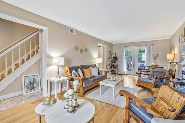 living room featuring crown molding, french doors, and light tile flooring