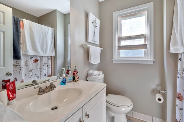 bathroom featuring a wealth of natural light, toilet, and large vanity