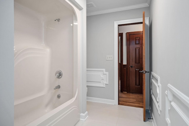 bathroom featuring tile patterned flooring, washtub / shower combination, and ornamental molding