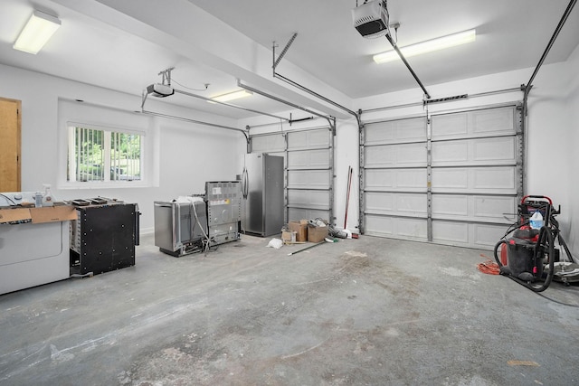 garage featuring stainless steel fridge with ice dispenser, washer / clothes dryer, and a garage door opener