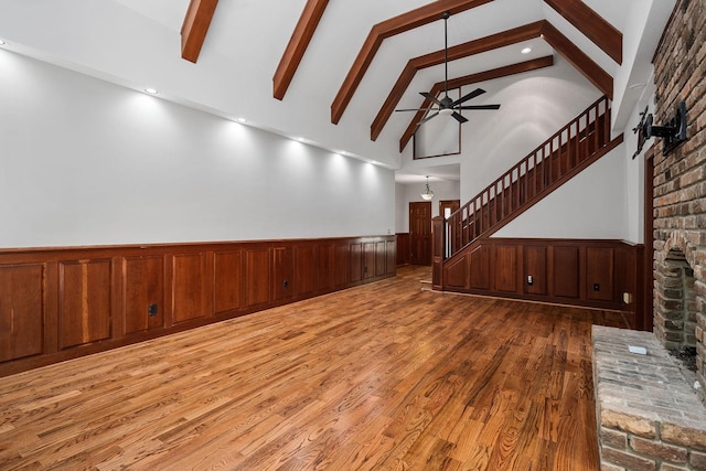 unfurnished room with hardwood / wood-style floors, ceiling fan, beam ceiling, and high vaulted ceiling