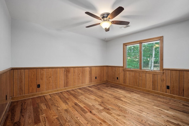 empty room with ceiling fan and light hardwood / wood-style flooring