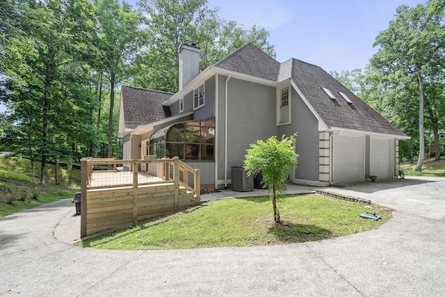 view of property exterior featuring central AC unit, a garage, and a wooden deck