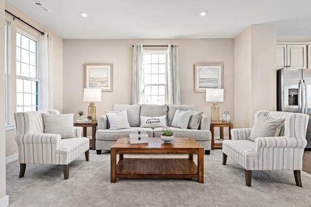 living room with plenty of natural light and light carpet