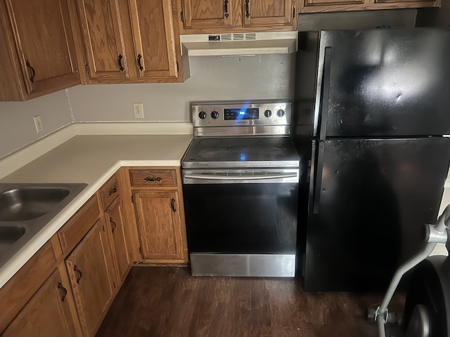 kitchen with stainless steel electric range, black refrigerator, sink, and dark hardwood / wood-style floors