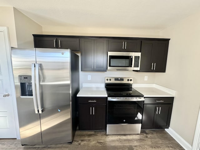 kitchen featuring hardwood / wood-style flooring, stainless steel appliances, and a textured ceiling