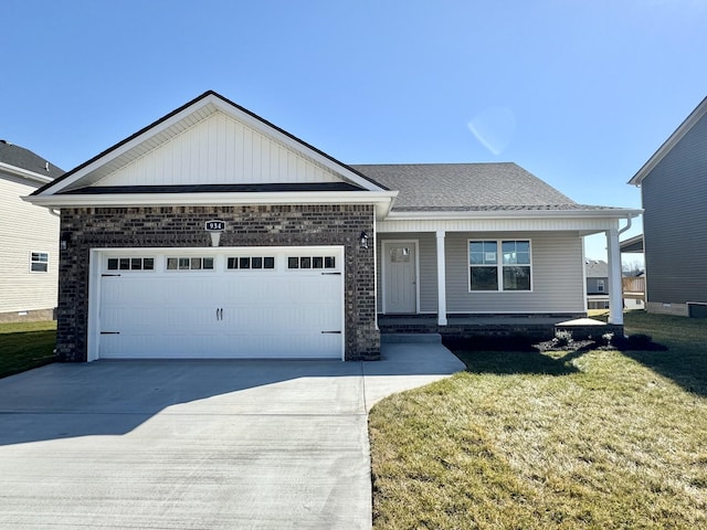 view of front of home featuring a porch, a garage, and a front yard