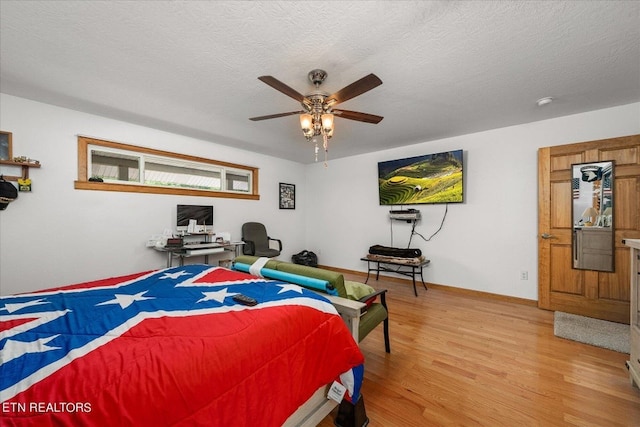 bedroom featuring wood-type flooring, ceiling fan, and a textured ceiling