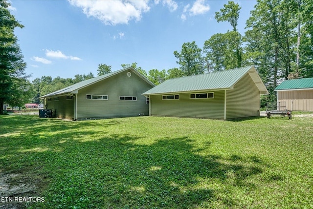 rear view of house with an outdoor structure and a lawn